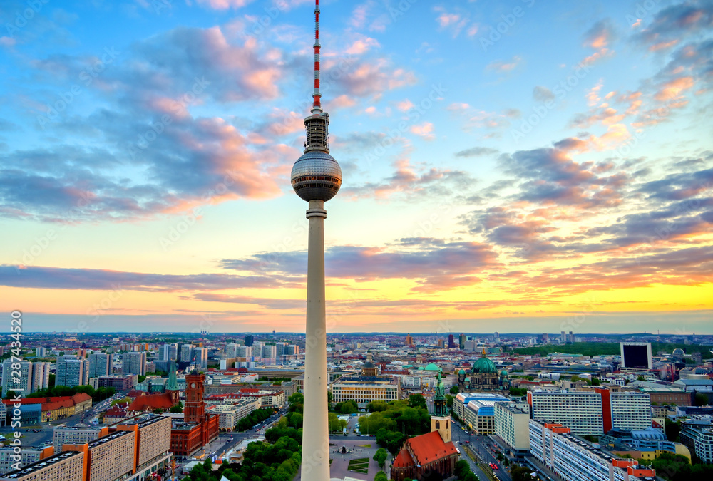 Fototapeta premium A view of the television tower (Fernsehturm) over the city of Berlin, Germany at sunset.