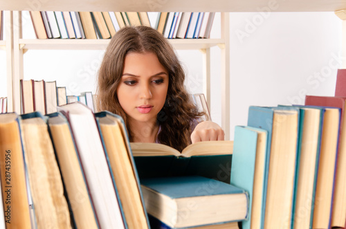 Young female student preparing for exams at library