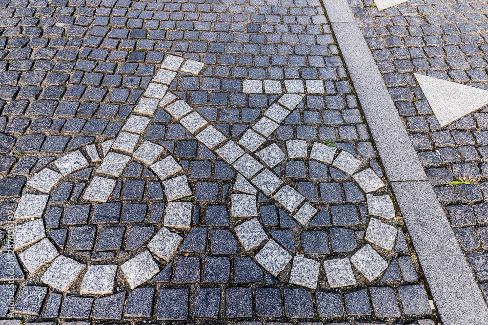 Bicycle road sign made of stone pavers on bike lane