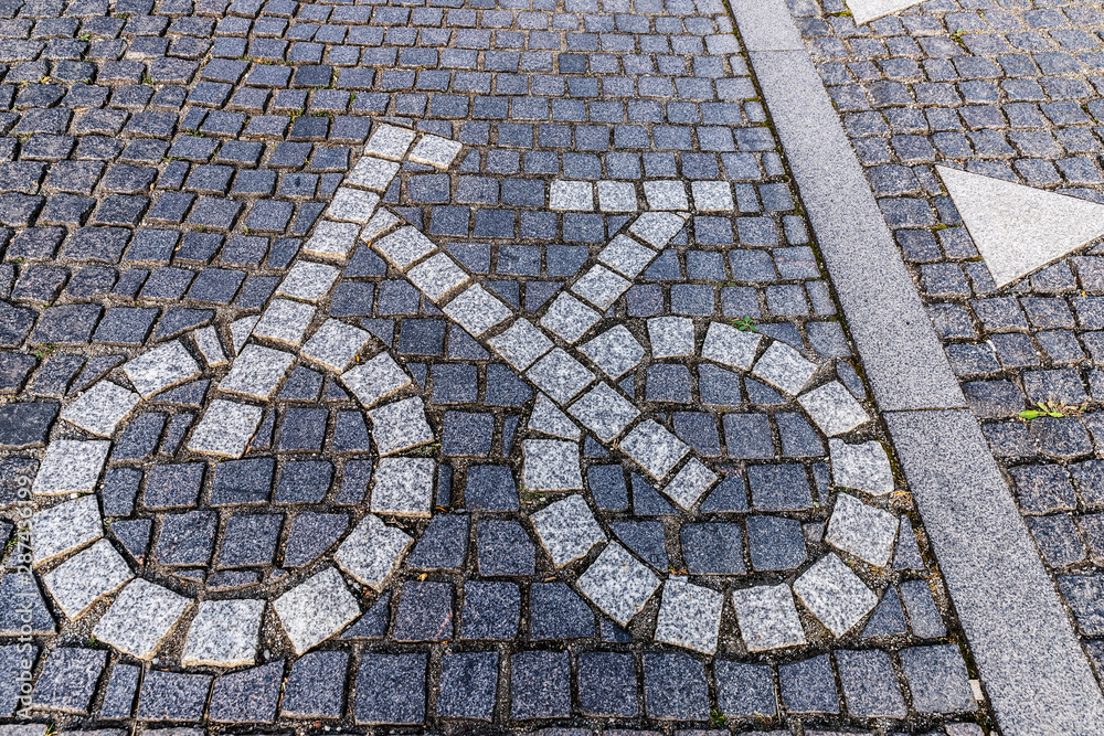 Bicycle road sign made of stone pavers on bike lane Bicycle road sign made of stone pavers on bike lane