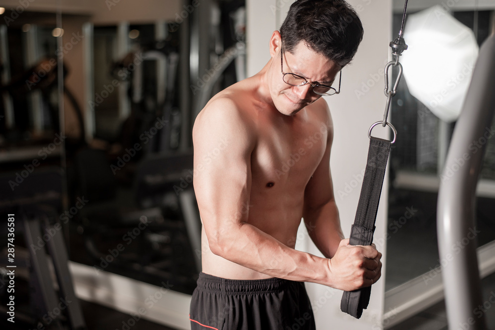 Asian man is working out  in fitness gym