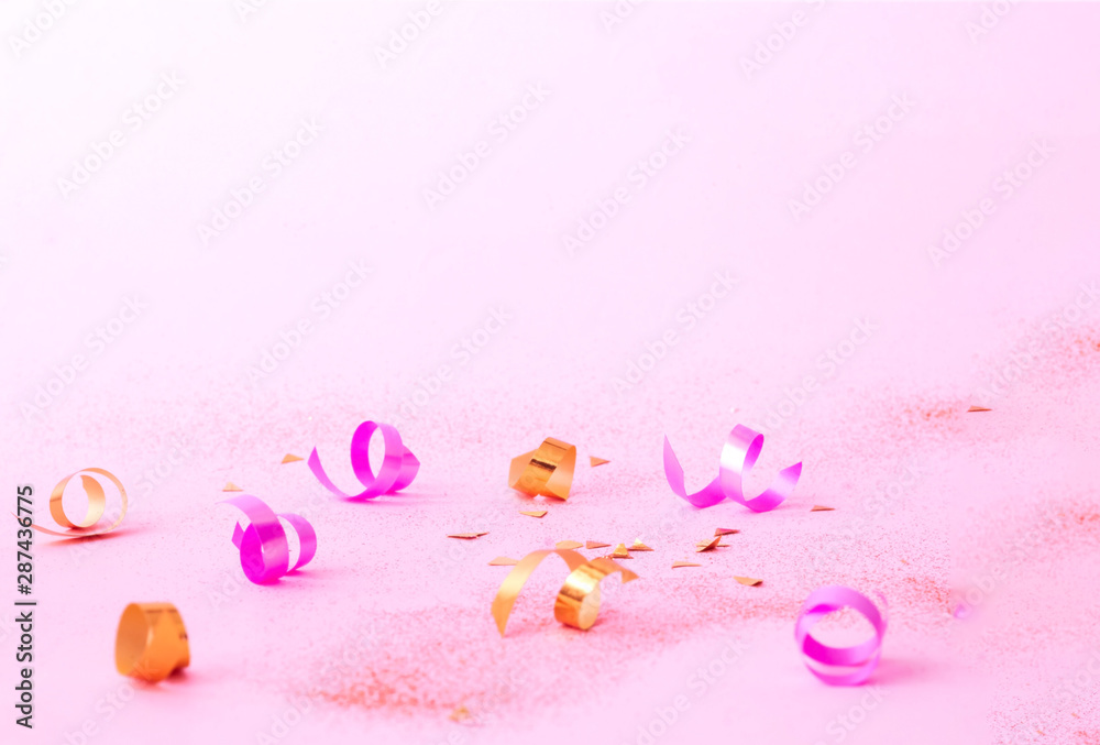Confetti on pink background with golden sparkles. Concept for festive background or for project