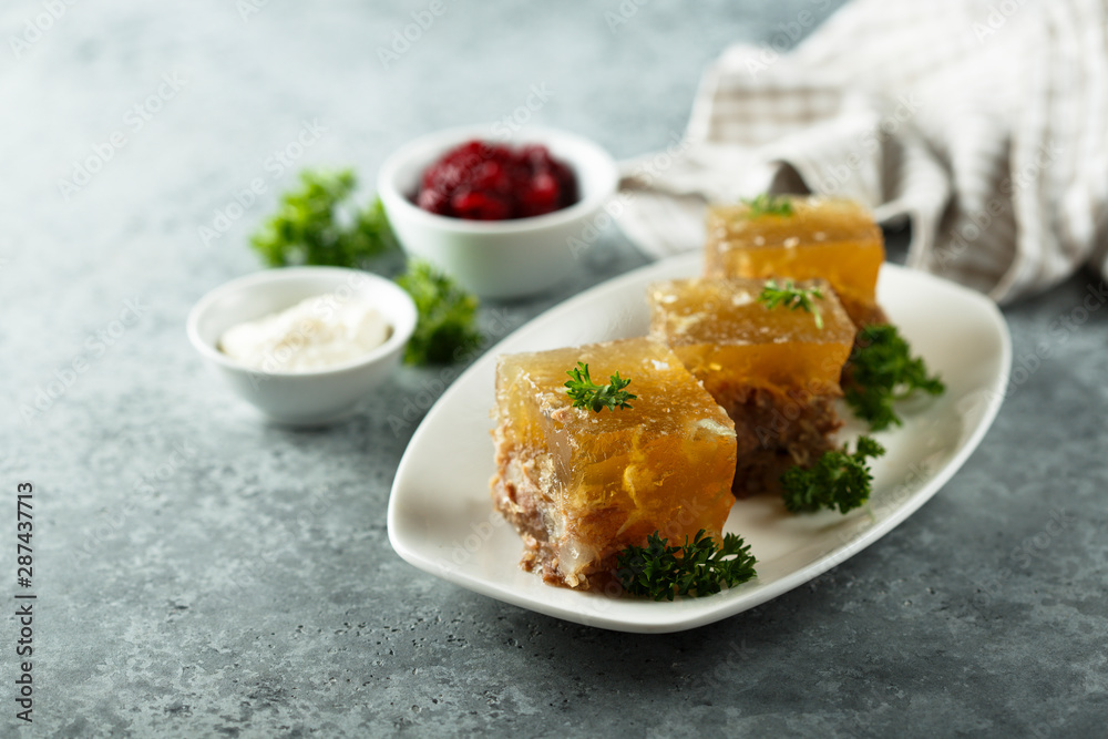 Festive meat jelly with sauces on white plate Festive meat jelly with sauces on white plate