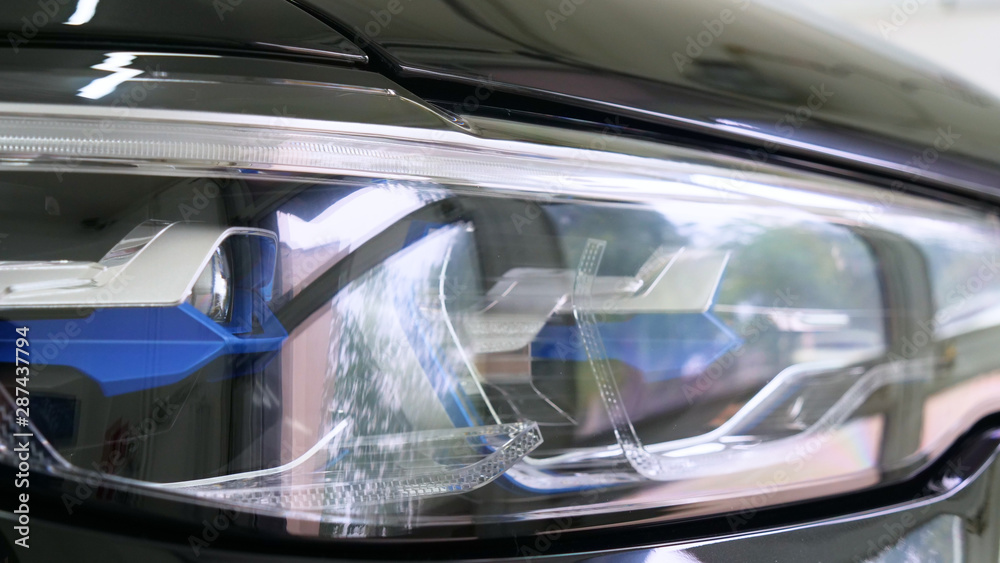 After professional polishing, ceramics and car washes show headlights on new cars. Concept of: Auto Service, Different Colors, Car wash, Presentation, Glittering Headlights.	