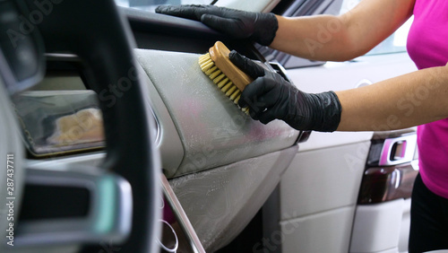 A woman at a car wash does a full dry-cleaning of all parts of a car using special chemistry, cloths, sponges and brushes. Concept of: Full car cleaning, Dry cleaning, Professional service. Car, Work. © dkHDvideo