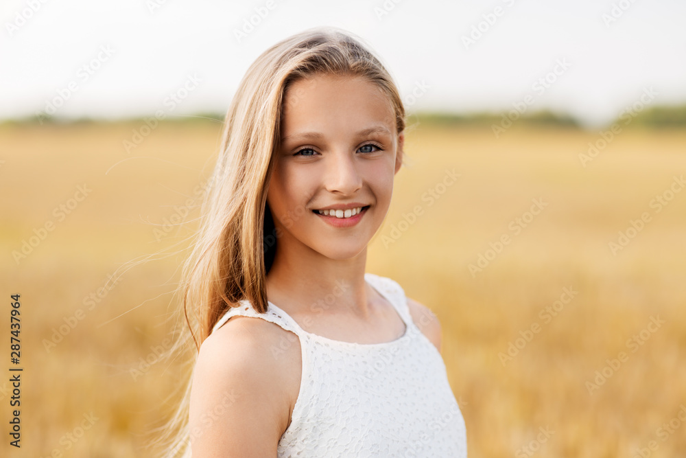 nature and people concept - smiling young girl on cereal field in summer nature and people concept - smiling young girl on cereal field in summer