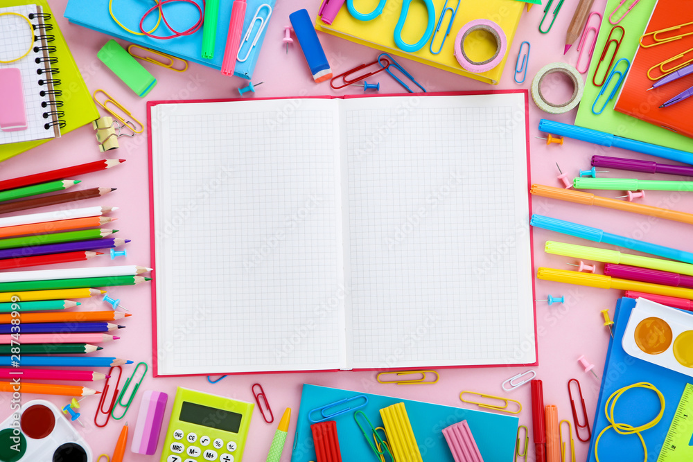 Different school supplies with opened notebook on pink background Different school supplies with opened notebook on pink background