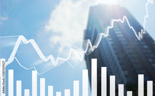 Low angle view of Stock market graph with volume indicator and blurred modern building with blue sky clouds  stock market and financial concept