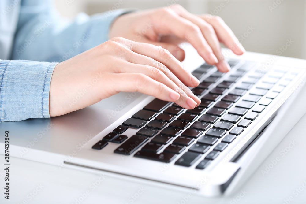 Female hands typing on laptop keyboard