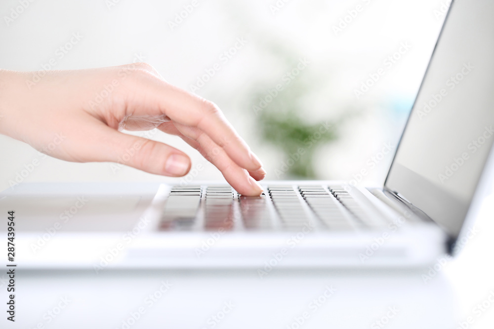 Female hand typing on laptop keyboard Female hand typing on laptop keyboard