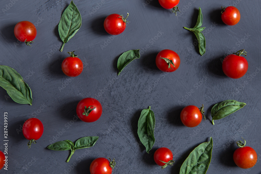 Fresh cherry tomatoes with basil leaves on a black background. Fresh cherry tomatoes with basil leaves on a black background.
