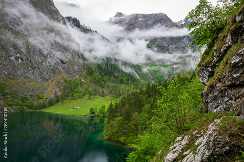 View of the mountains in Berchtesgaden on the Koenigssee with clouds in the sky and stones and rocks in the foreground