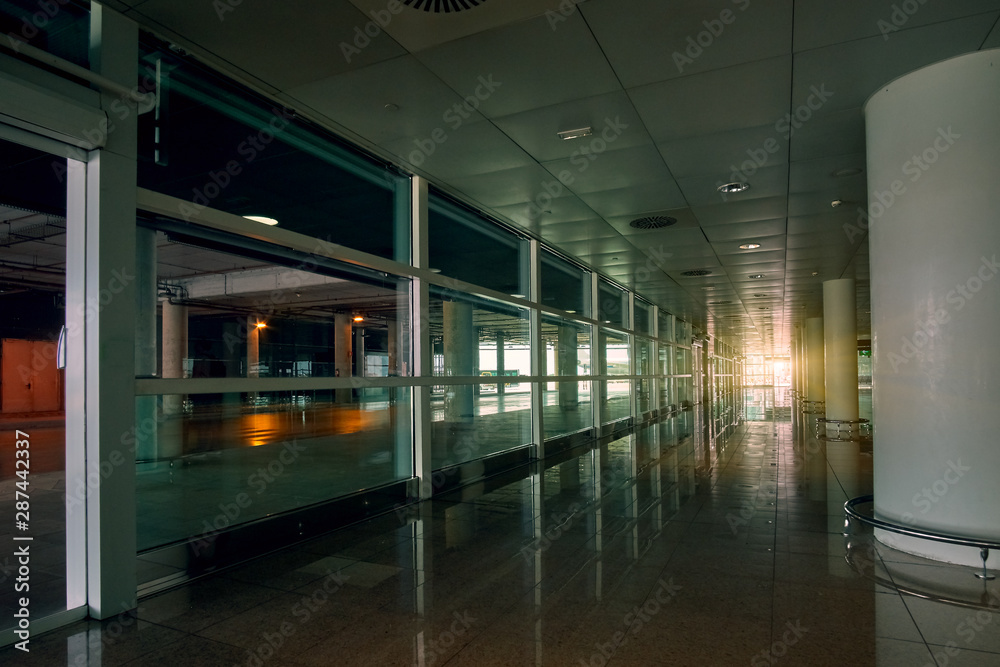 Empty modern international airport hall with sunset sunlight on background
