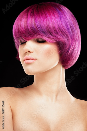 Pink or purple colored hair model portrait on black background. Girl portrait with Pink colour hair style