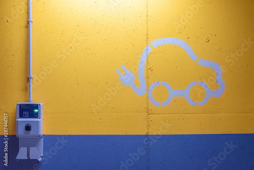 Fototapeta Naklejka Na Ścianę i Meble -  Electric vehicle logo on the ground of a parking space