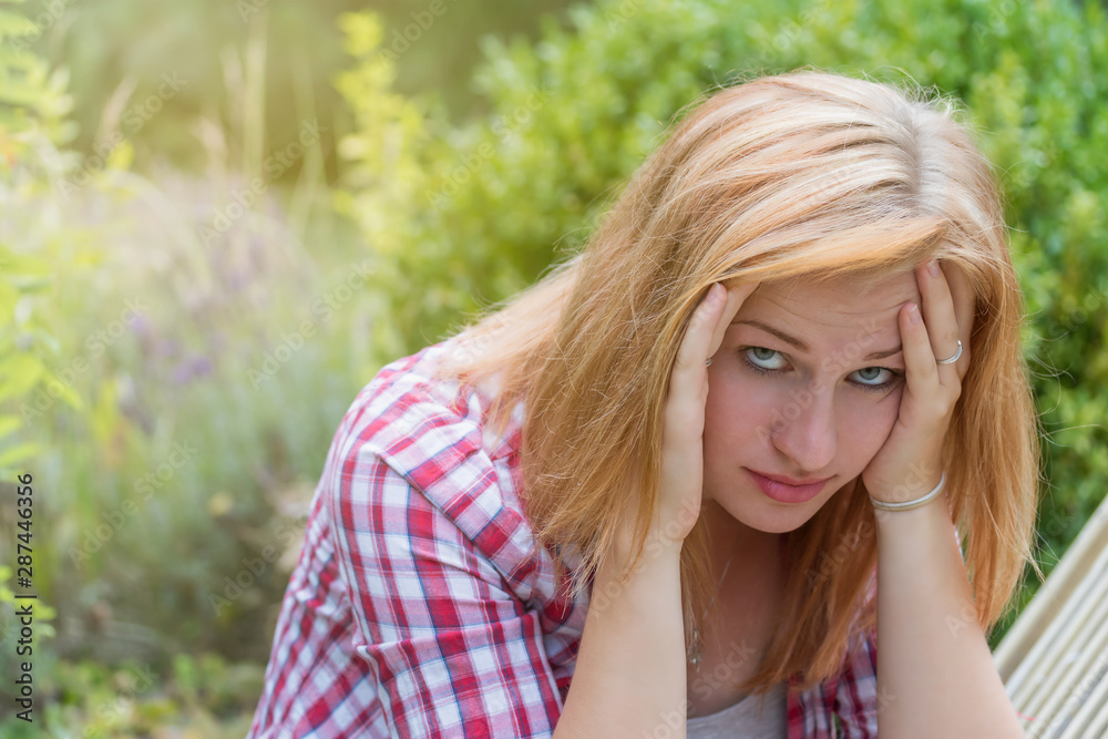 Attractive young woman holding her hand over her head and looking at the camera. She is depressed and thinking about how to solve problem Attractive young woman holding her hand over her head and looking at the camera. She is depressed and thinking about how to solve problem