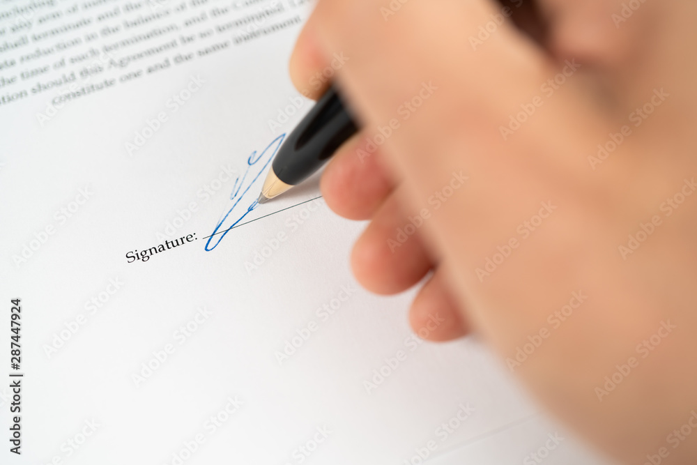 Close up hand with pen on the signature line on a contract ready to be signed Close up hand with pen on the signature line on a contract ready to be signed