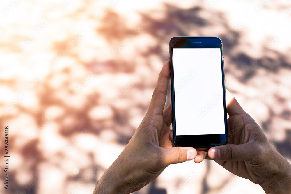 Man's hands holing portable mobile phone with white empty screen with copy space background for your promotional content. Hipster person chattion online on smartphone with blank monitor.