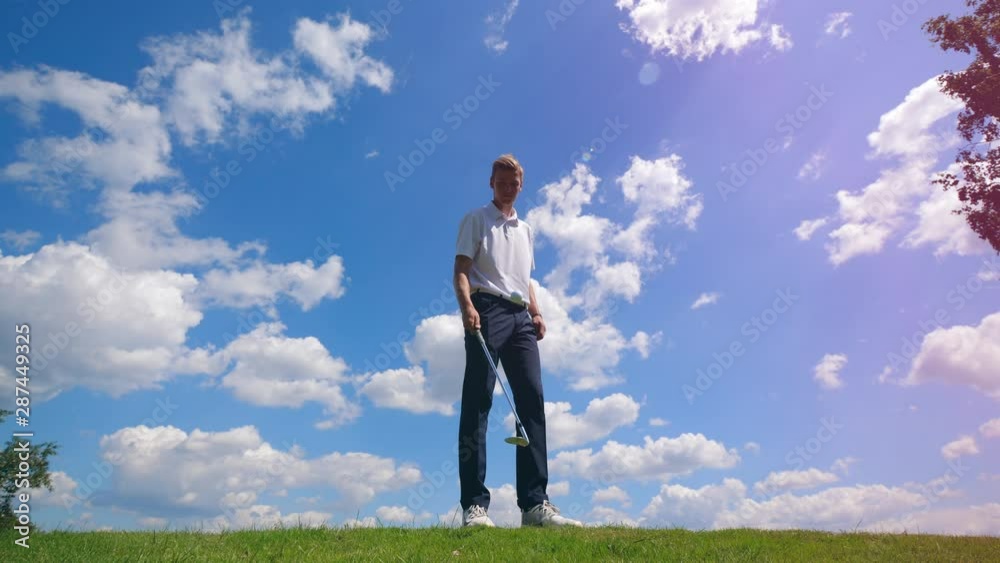 A man juggles golf ball with a golf club. A man juggles golf ball with a golf club.