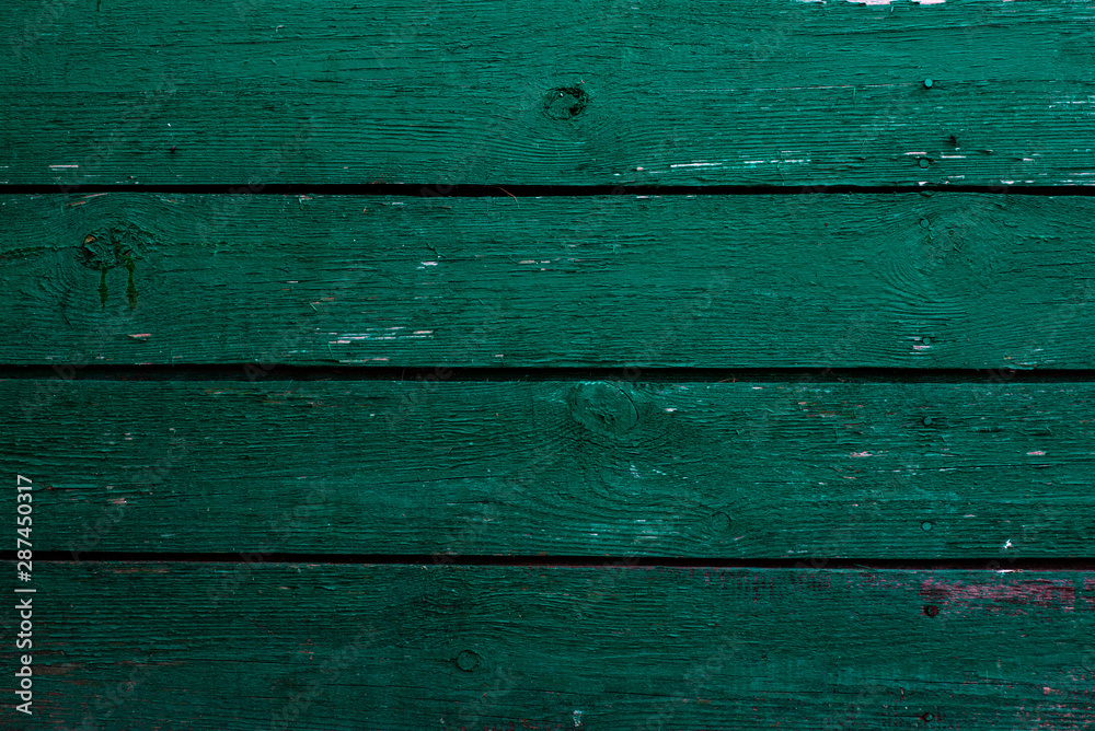 The texture of the green wall of wooden boards with cracked paint. The texture of the green wall of wooden boards with cracked paint.