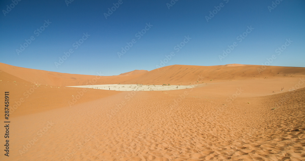 Dead vlei mit toten Bäumen im Sossusvlei in der Wüste Namib in Namibia mit Dünen aus rotem Sand im Hintergrund