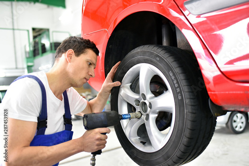 tyre change in a car repair shop - worker assembles rims on the vehicle © industrieblick