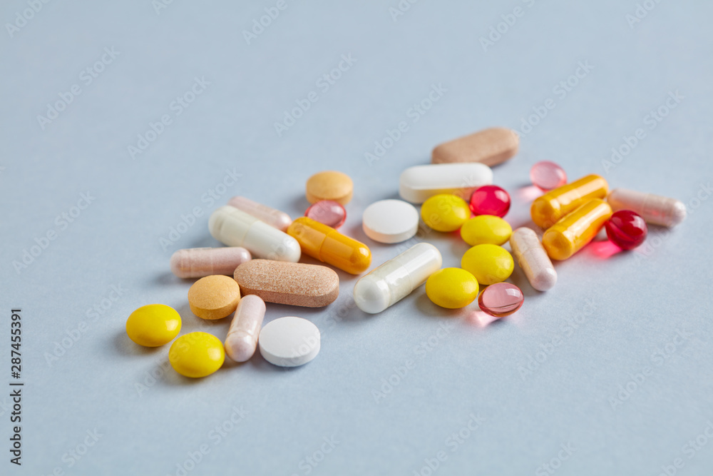 Vitamins and supplements on bright paper background. Concept for a healthy dietary supplementation. Close up. Copy space. Vitamins and supplements on bright paper background. Concept for a healthy dietary supplementation. Close up. Copy space.