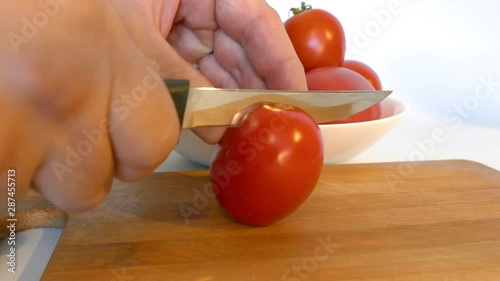 Сutting tomatoes with a knife. Cooking vegetables.