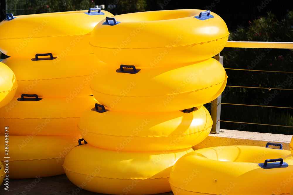 Group of big yellow swim rings in water park for using it on swimming