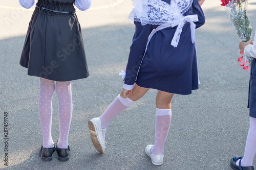 September. beginning of the school year. back view. girl straightens white stockings.