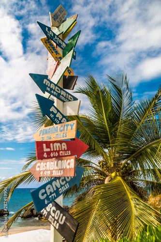 Directional sign on the beach indicating different wold destinations, photographed in the Dominican Republic. photo