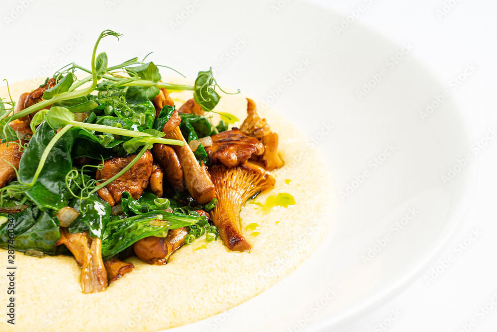 polenta with chanterelles on the white plate polenta with chanterelles on the white plate