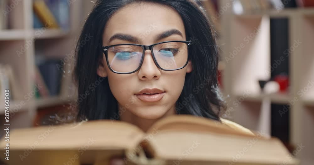 Female asian student is spending her time in library, examining a book and carefully reading the contents - student lifestyle, education concept 4k close up Female asian student is spending her time in library, examining a book and carefully reading the contents - student lifestyle, education concept 4k close up