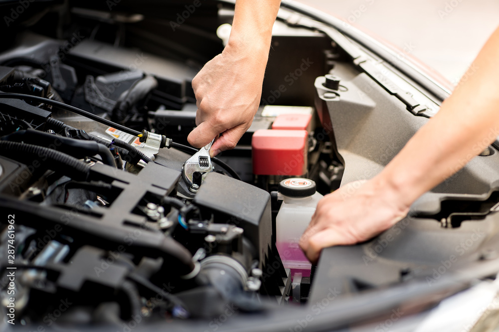 Mechanic man working and repair car engine in car service centre.Automobile metal car engine part details.Concept of modern vehicle motor,Industry,Mechanic and Business.
