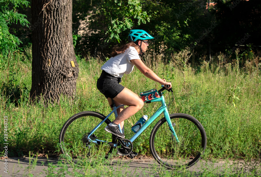 Fototapeta premium young beautiful woman riding a bicycle in a park. Active people. Outdoors