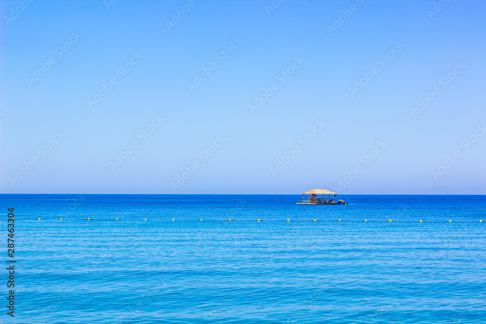 beautiful summer vacation destination Bungalow wooden house floating on a Red sea water surface in Gulf of Aqaba with horizon empty sky background with space for copy or text