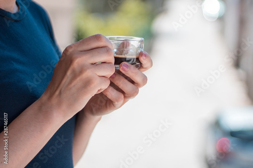 Young woman relaxing casually and looking at the landscape while holding a cup of coffee