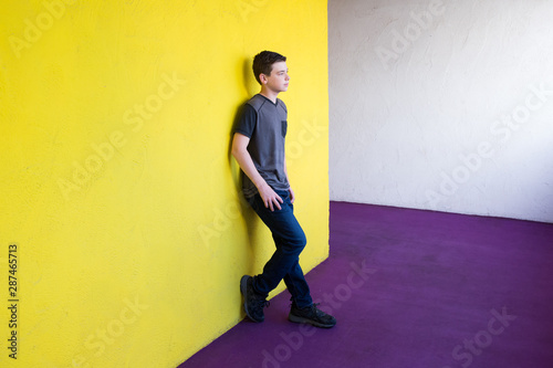 sad depressed handsome boy leaning on yellow wall