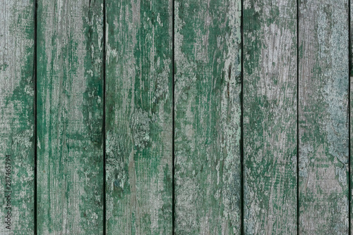 A photo of the rough wood planks texture painted in green long time ago