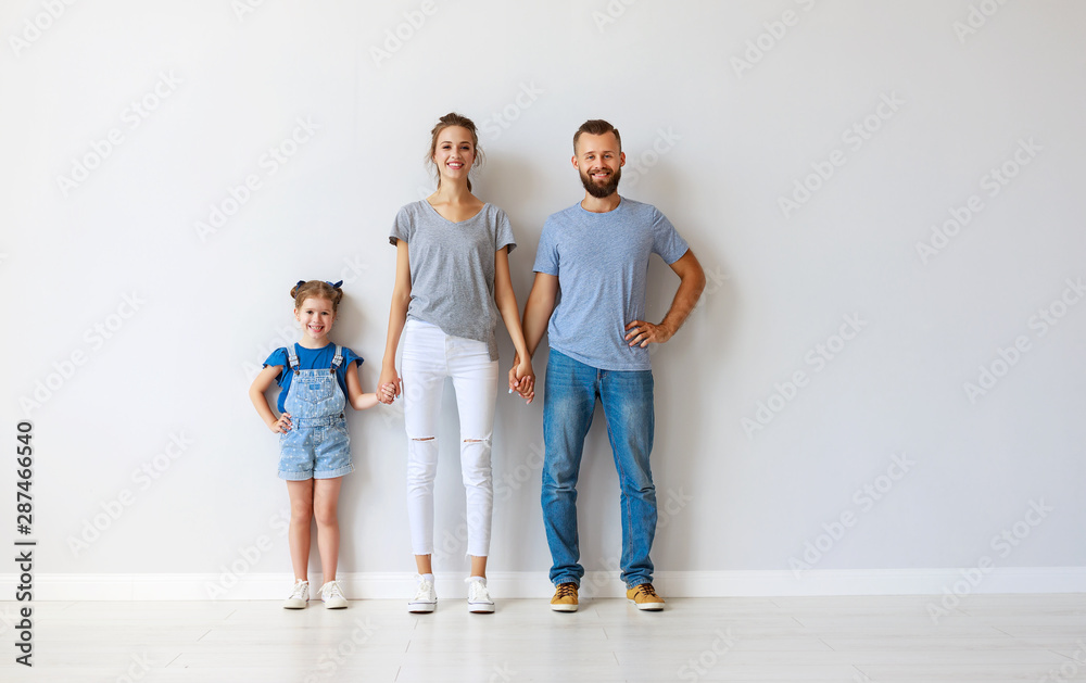 happy family mother father and child near an empty wall happy family mother father and child near an empty wall