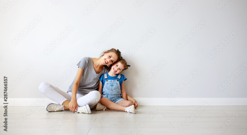 happy family mother (big sister) and child daughter near an empty wall happy family mother (big sister) and child daughter near an empty wall