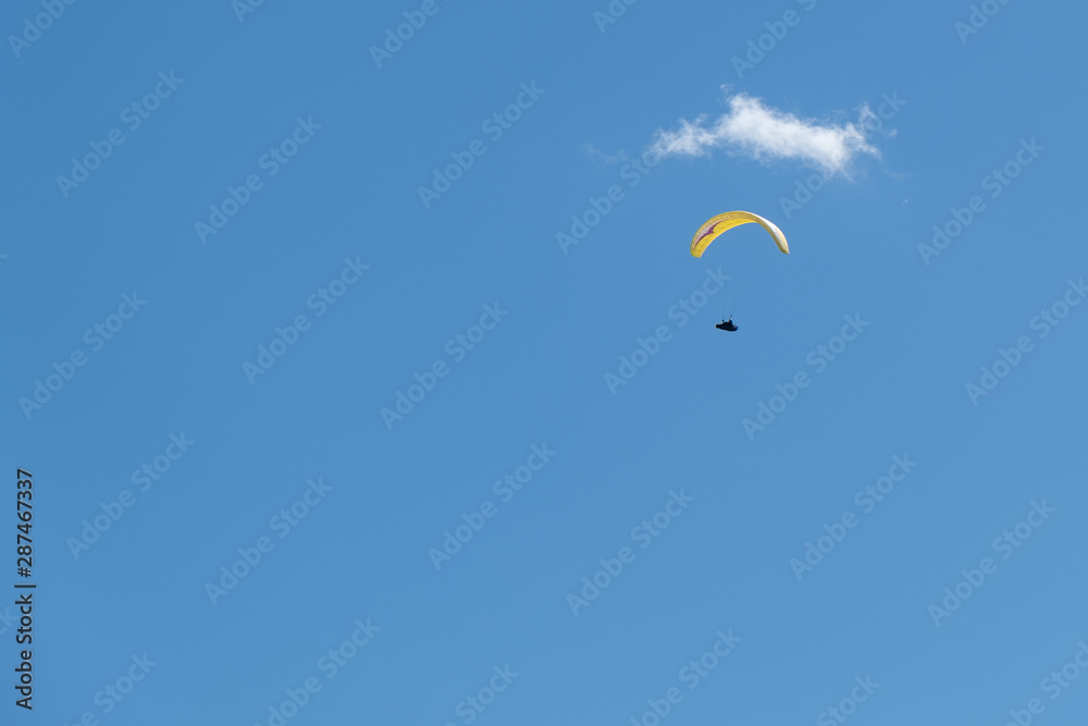 Paraglider below small cloud in the sky, nobody, copy space Paraglider below small cloud in the sky, nobody, copy space