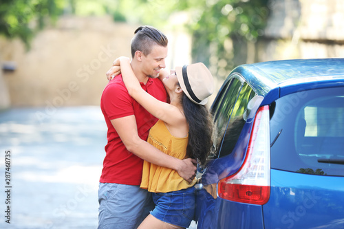 Happy young couple near car...