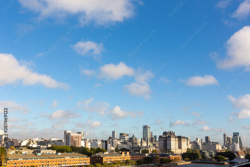 Obraz premium Beautiful skyline view of Buenos Aires, Argentina city center from Puerto Madero in sunny summer day with blue sky. Skyscraper office architecture, old buildings and city apartments.
