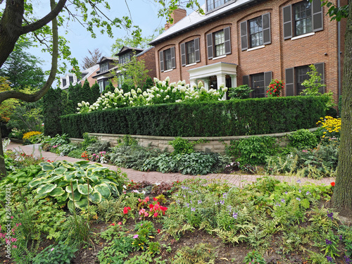 Photography Residential street with large houses and flower bed on both sides of public side