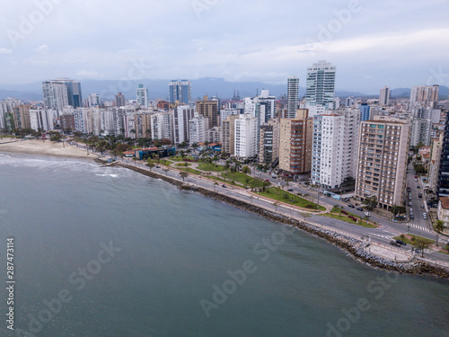 Beautiful aerial drone view of Santos city in Sao Paulo, Brazil. Panoramic Santos skyline with beach, sea, streets and buildings with mountains in the background in foggy day. © Imago Photo