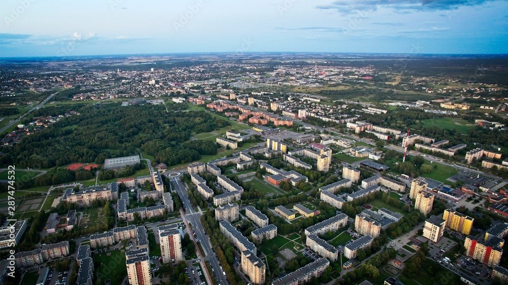 Aerial panoramic view of the southern part of Siauliai city in Lithuania.Old soviet union buildings with green nature, park shopping center and countryside on the background