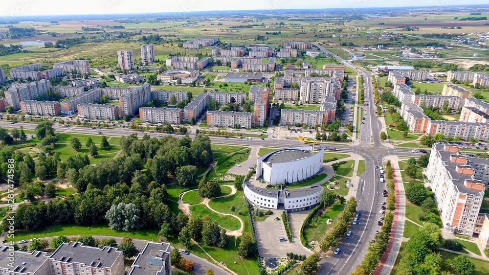 Aerial panoramic view of the southern part of Siauliai city in Lithuania.Old soviet union buildings with green nature around, park and modern church