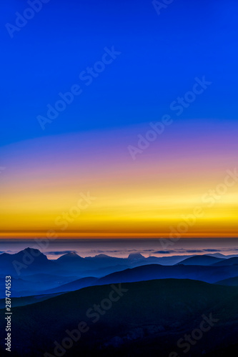 Yellow, blue sunset, Ocean, Mountains, silhouetted