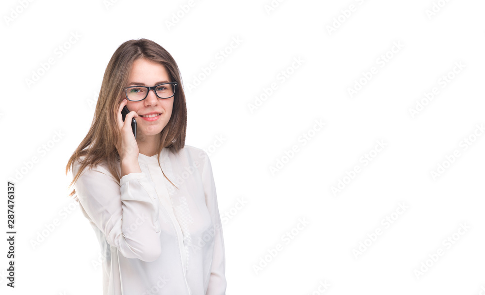 Smiling businesswoman in glasses talking on mobile phone. Beautiful young girl in white shirt on white isolated background talking on mobile phone. Woman in shirt with cellphone. Copy space. Blank